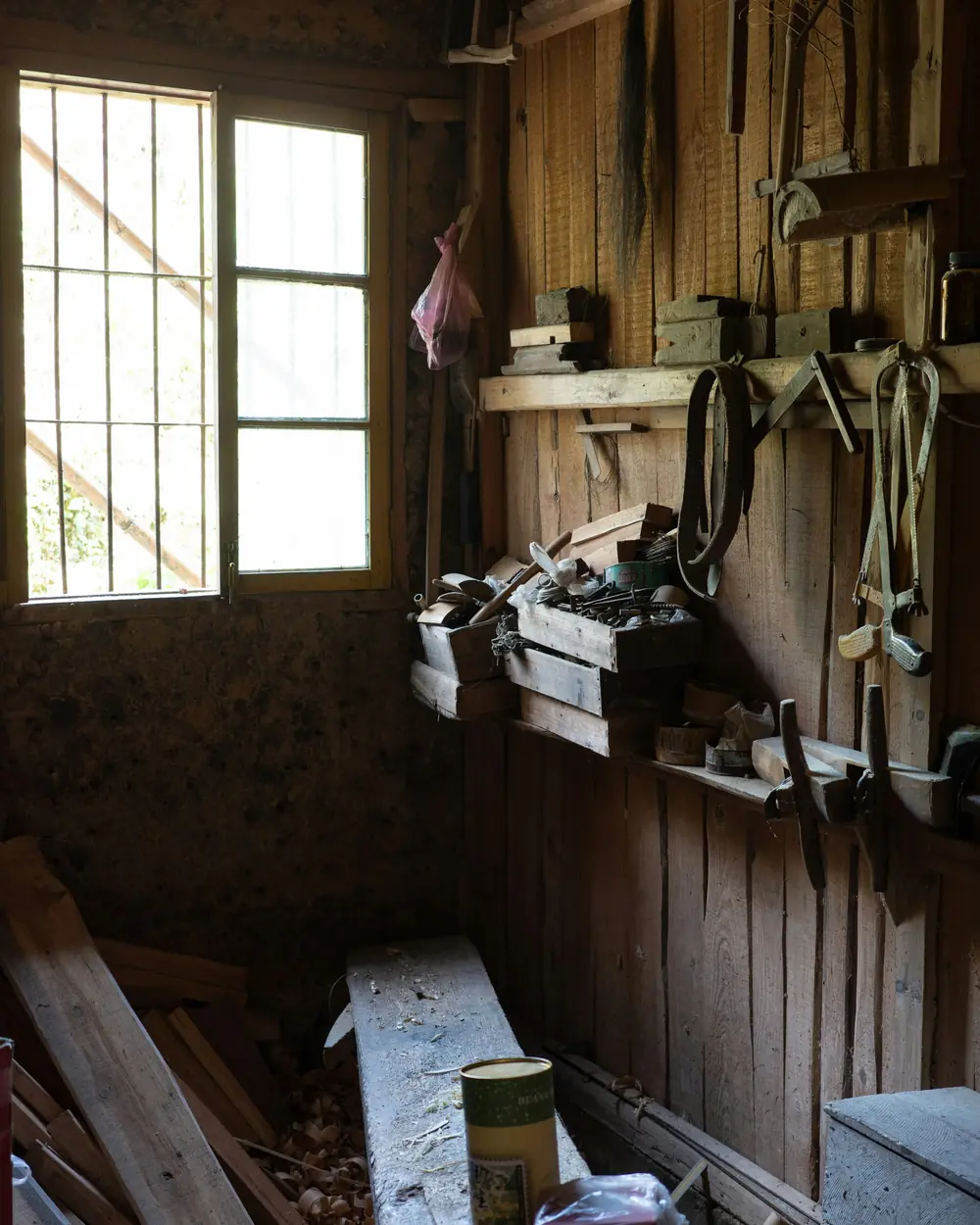 Sunlit woodworking workshop with hand tools hanging on the wall