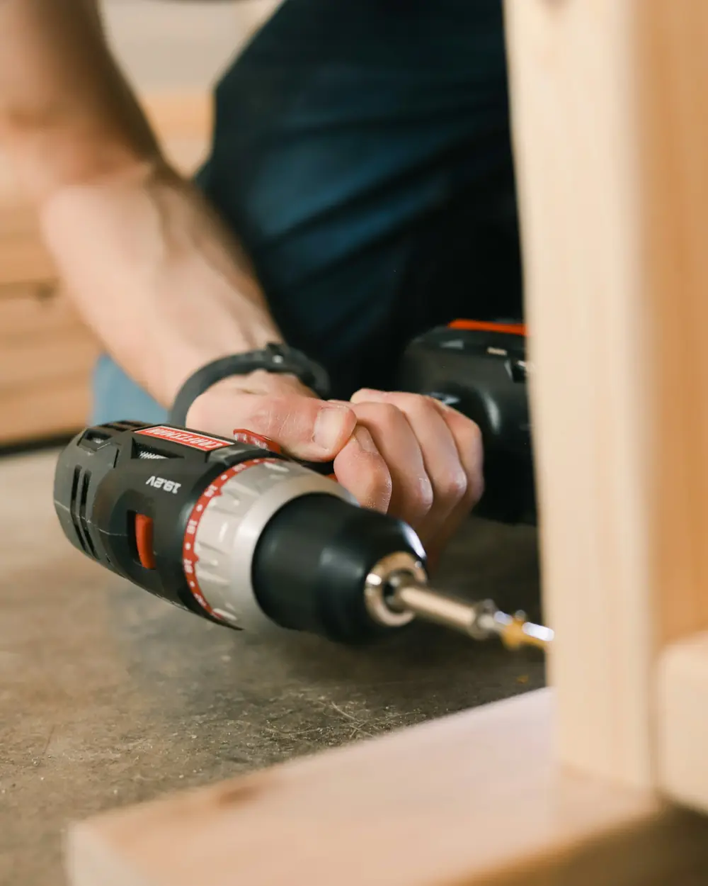 Installer fixing a solid wood frame with a cordless drill