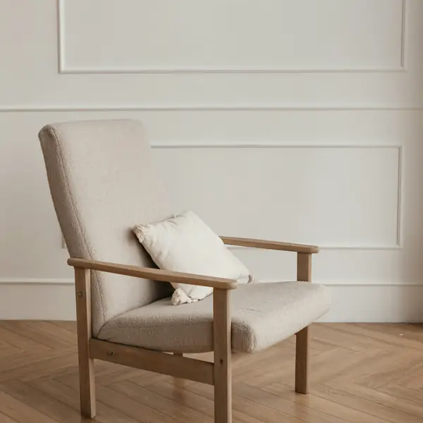Oak armchair with an ivory cushion on herringbone flooring