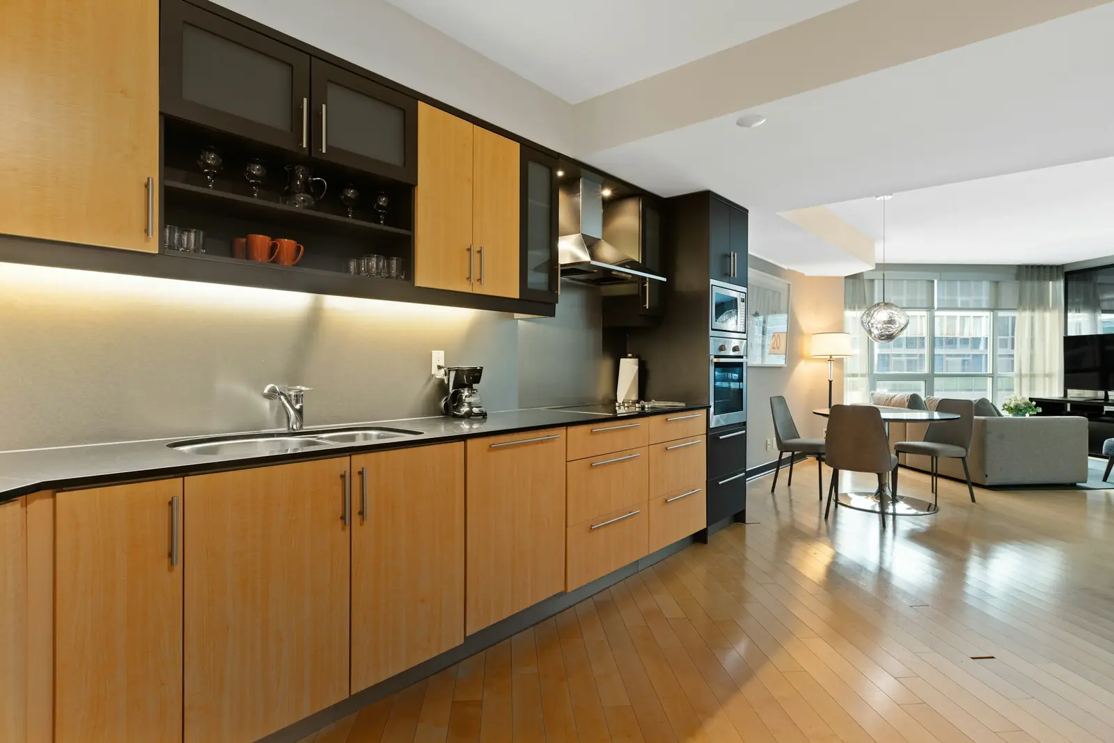 Long modular kitchen with warm wood-grain shutters and dark upper cabinets