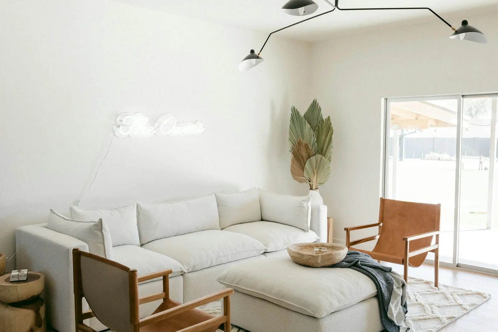 Bright living room with an ivory sectional sofa and a leather sling chair