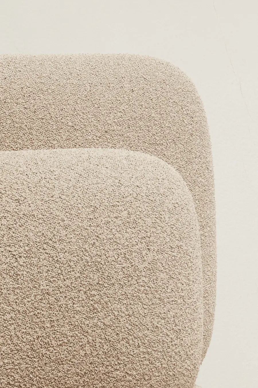 Close-up of soft ivory bouclé upholstery on a curved chair