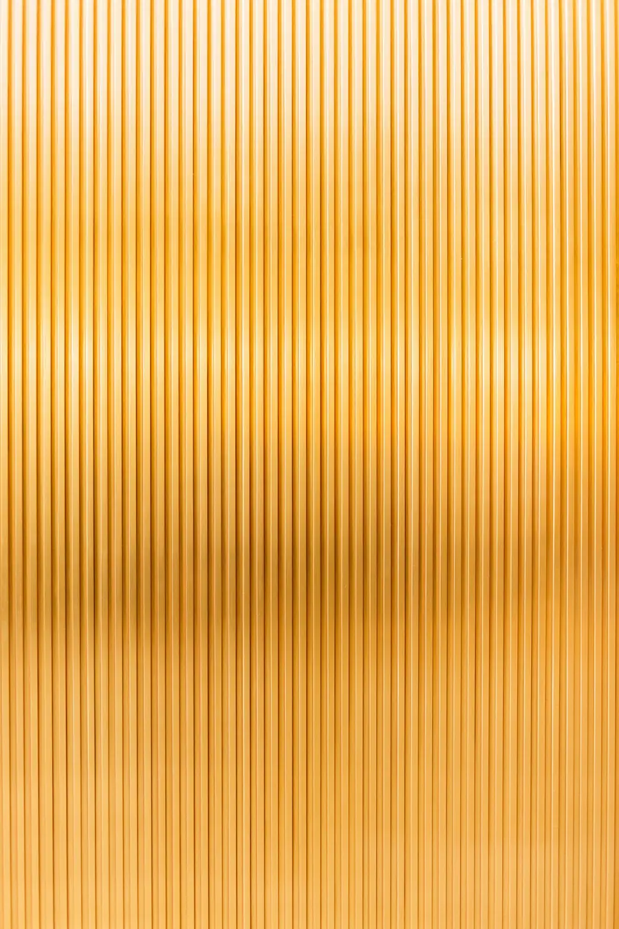 Fluted brushed-brass surface catching the light
