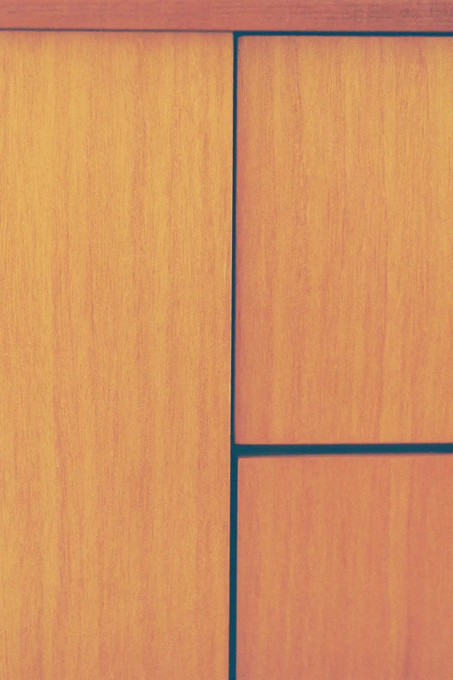 Teak drawer fronts with recessed handles in warm light