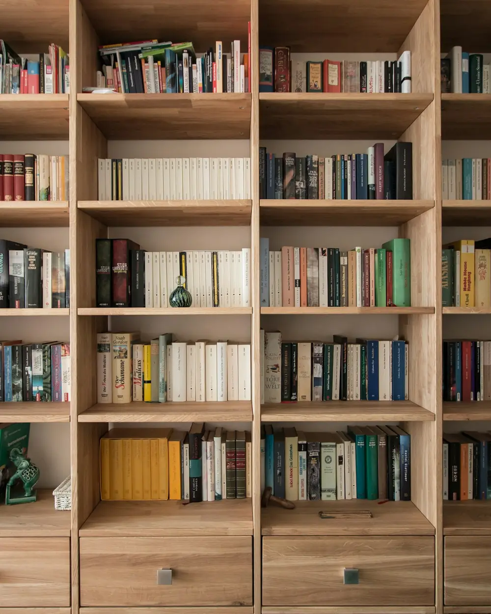 Floor-to-ceiling solid oak library shelving filled with books