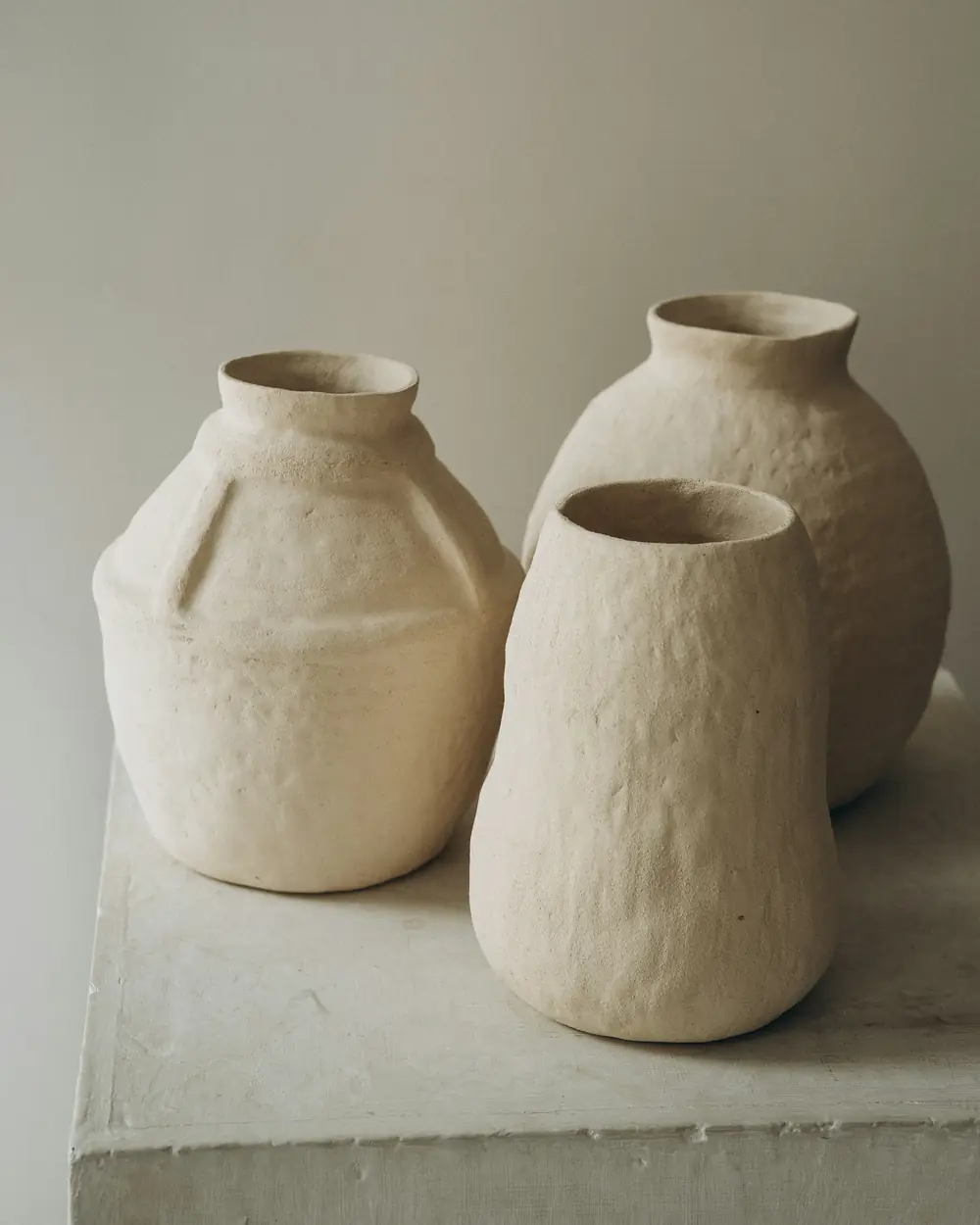 Three hand-thrown textured stoneware vessels in soft light