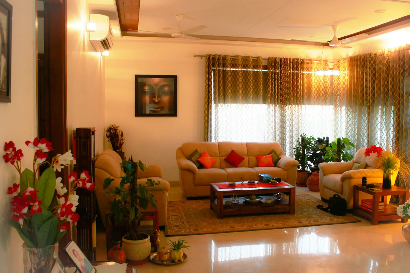 Indian living room with beige sofas, a carved coffee table and warm patterned curtains