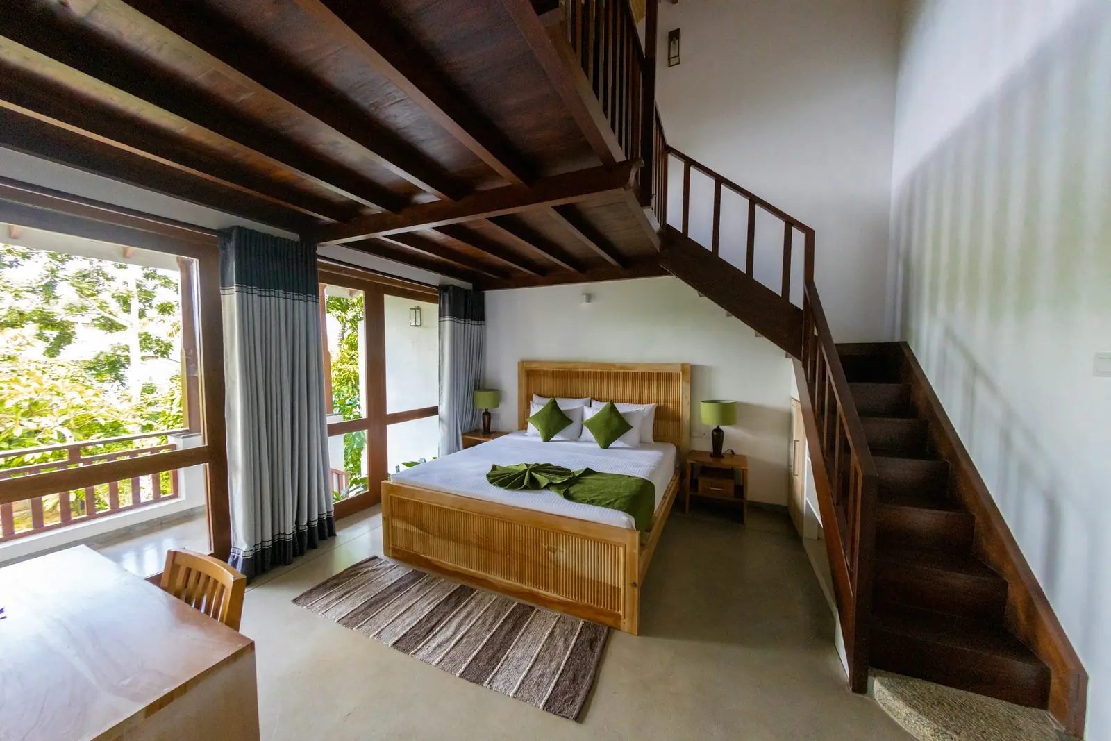 Bedroom under a timber ceiling with a solid wood bed and a wooden staircase